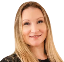 Woman with long blonde hair, smiling, looking at the camera.