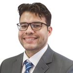 Woman with blonde hair and teal glasses smiling.