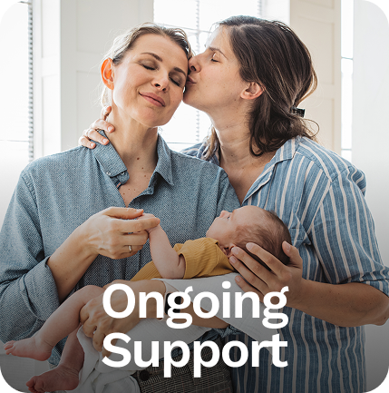 Two women embracing a baby; one kisses the other's cheek. The text reads