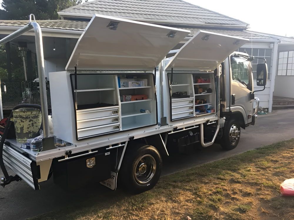 A Truck With The Doors Open Is Parked In Front Of A House — Aquafix Plumbing Services in Bowral, NSW