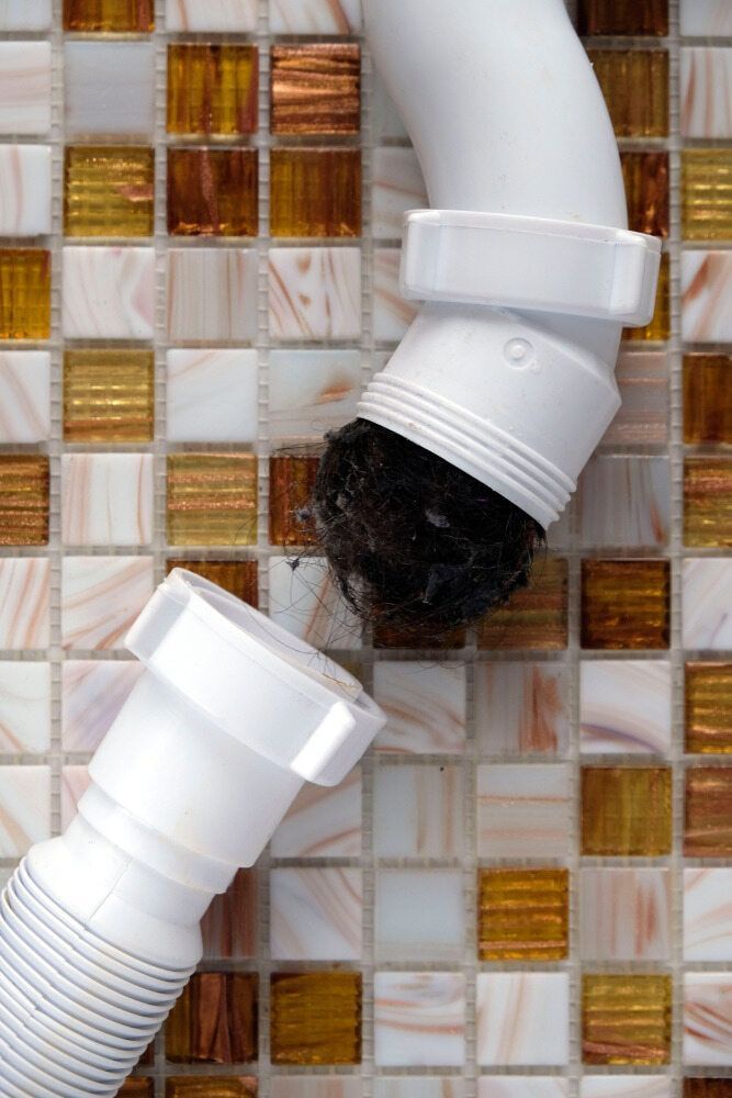 A Drain Pipe On A Tiled Wall — Aquafix Plumbing Services in Bowral, NSW