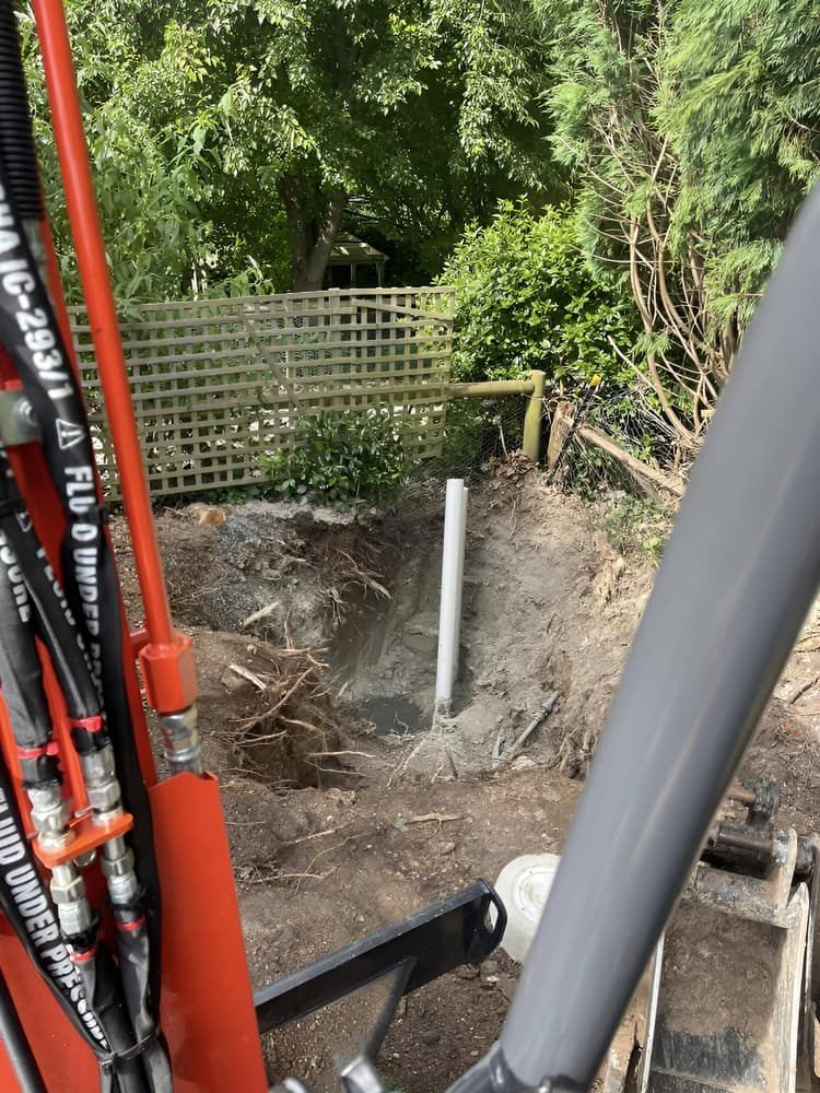 A Hydraulic Excavator Is Digging A Hole In The Ground — Aquafix Plumbing Services in Bowral, NSW