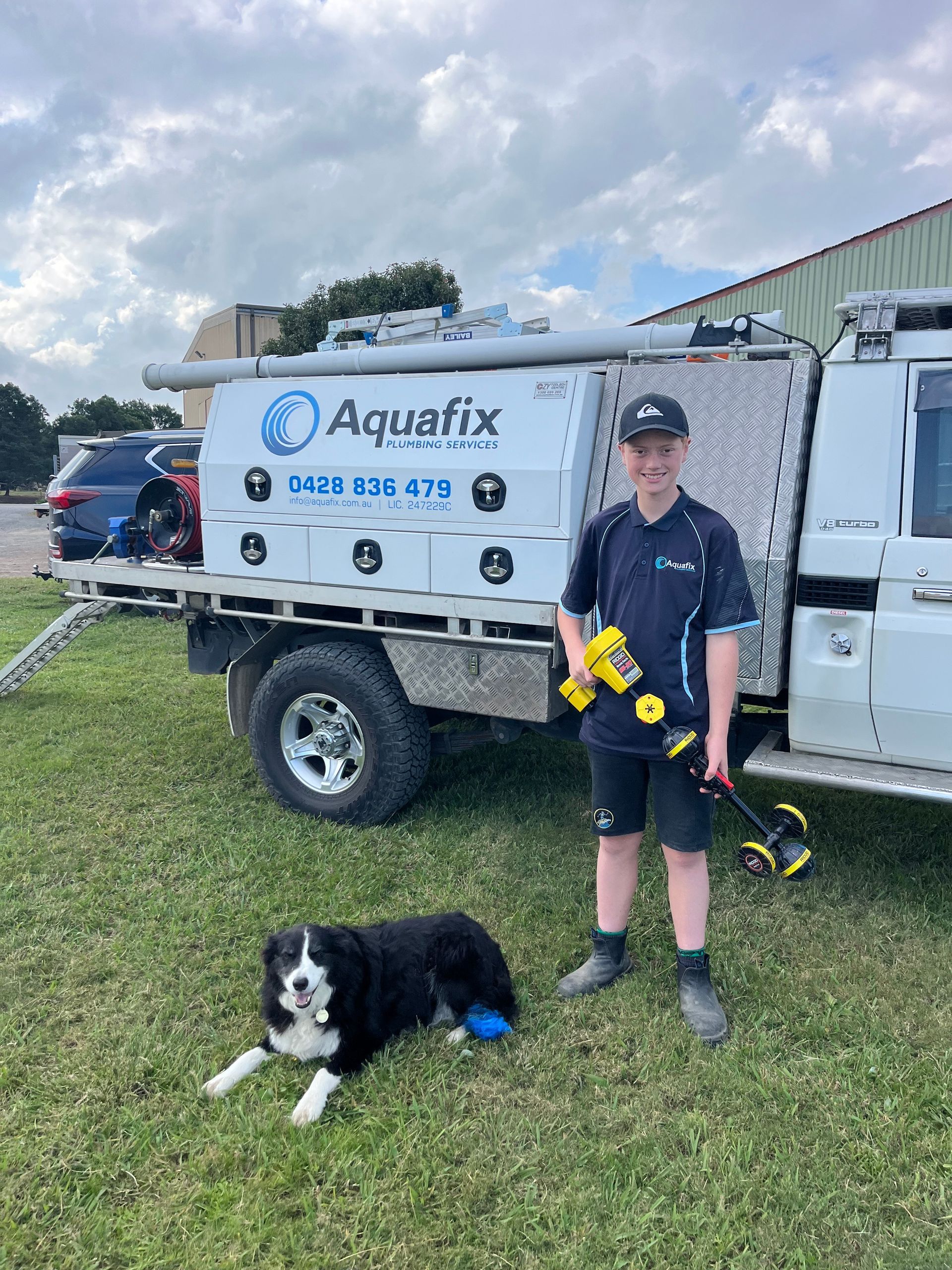 A Man Wearing Headphones Is Holding A Dog's Head — Aquafix Plumbing Services in Bowral, NSW