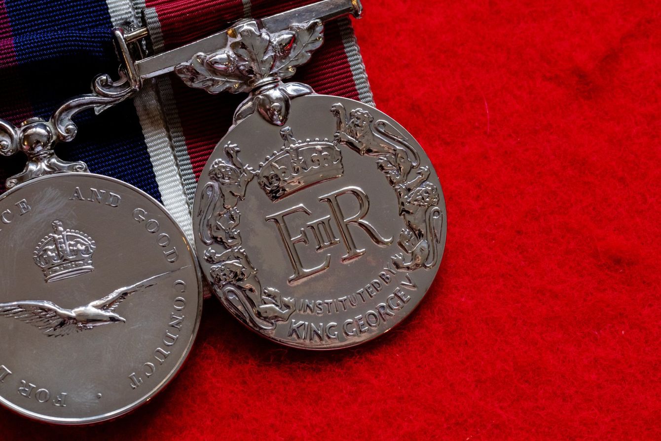 a silver medal with the letters er on it