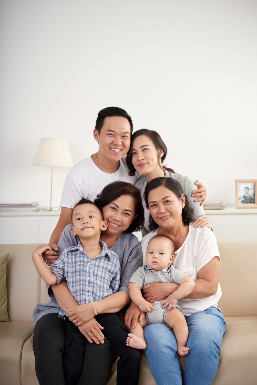 Family of six posing on a couch, smiling at the camera.