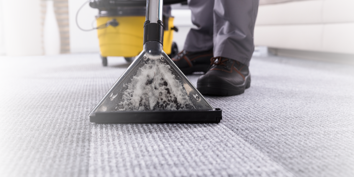 Person Cleaning Carpet with Vacuum Cleaner - Total Clean Services