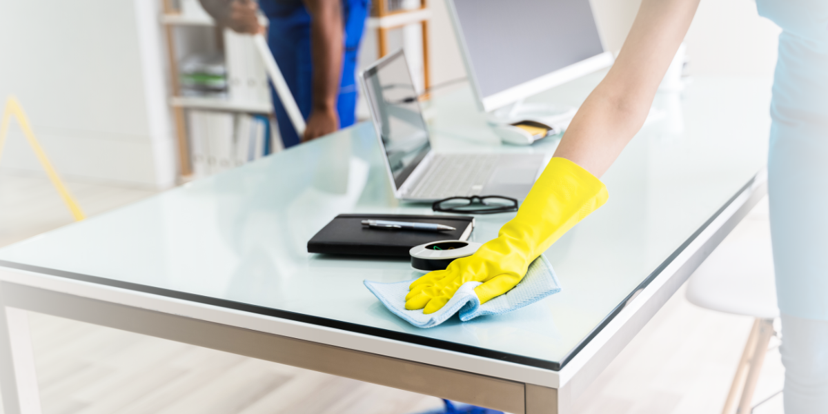 Person Wearing Yellow Gloves Cleaning Desk with Cloth - Total Clean Services