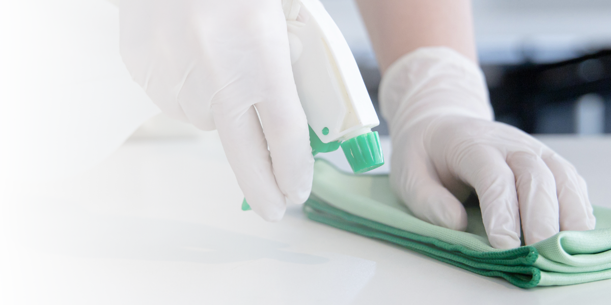 Person Wearing Gloves Cleaning Counter with Cloth and Spray Bottle - Total Clean Services