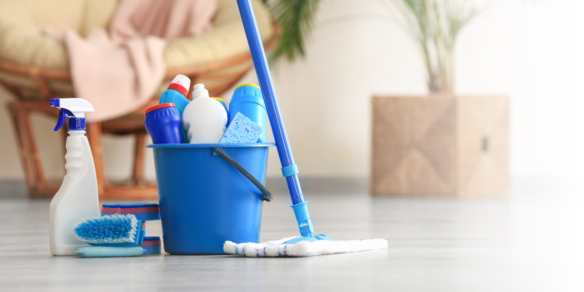 Mop, Bucket, Spray Bottles, and Brushes on Living Room Floor - Total Clean Services