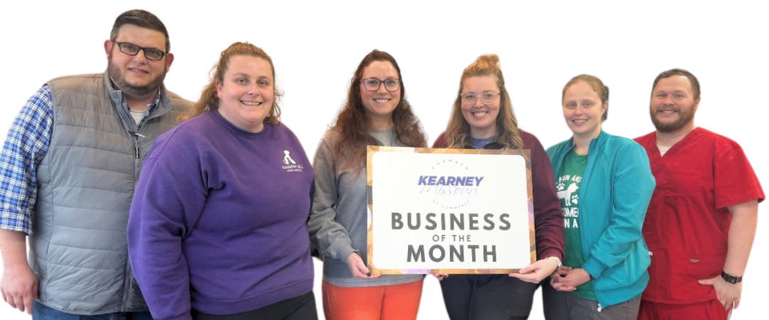A group of people standing next to each other holding a sign that says business of the month.