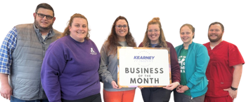 A group of people standing next to each other holding a sign that says business of the month.