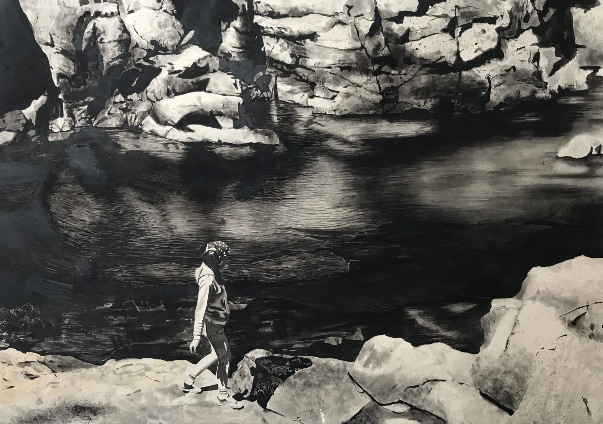 A black and white photo of a person standing on a rock near a river