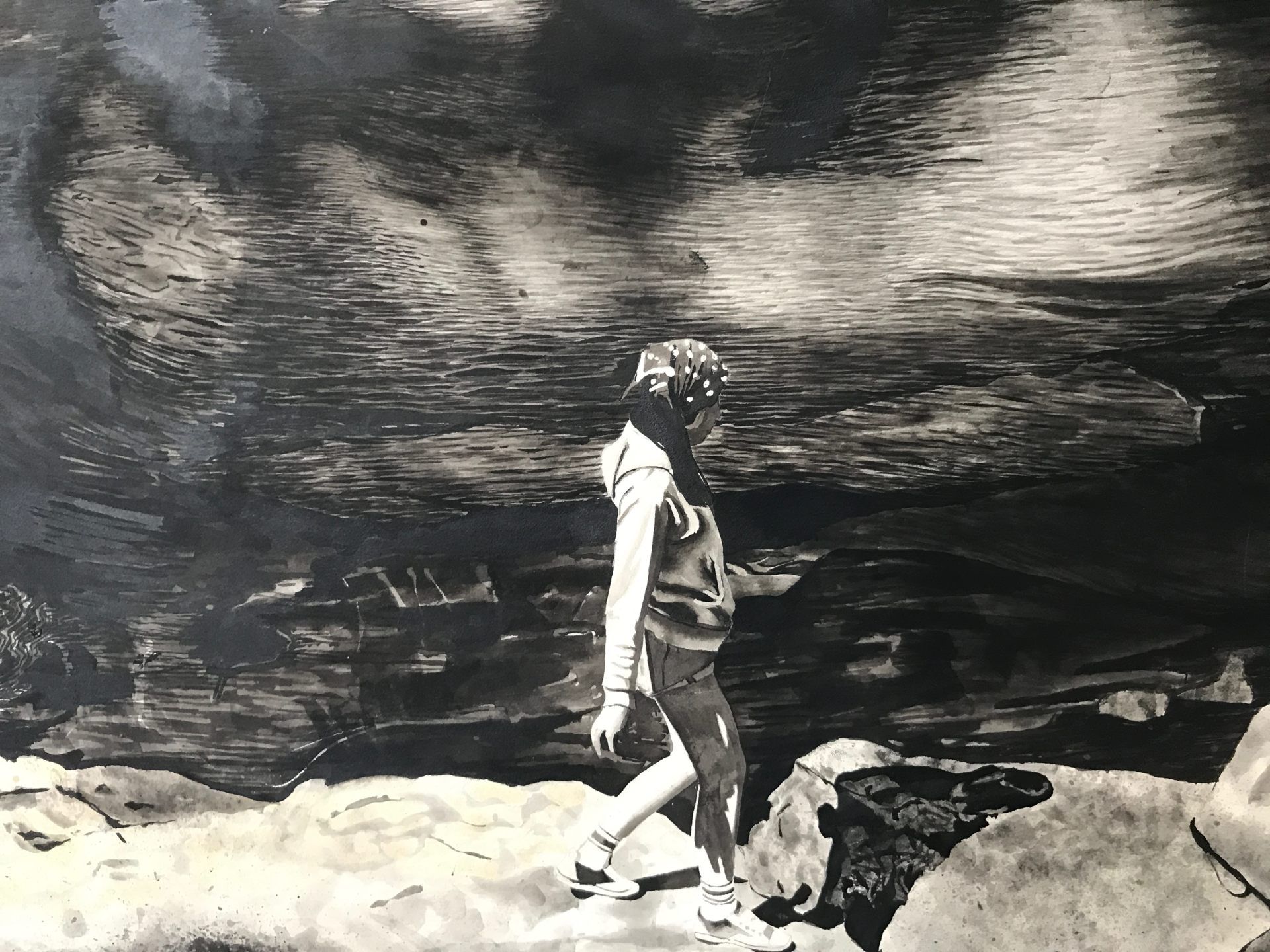 A black and white photo of a person crossing a river