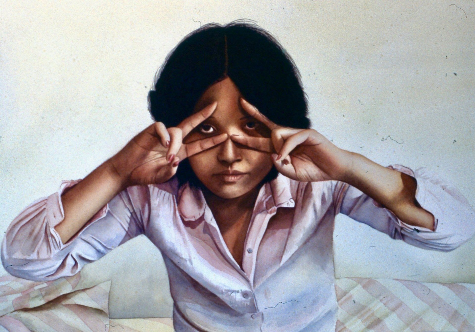 A woman in a pink shirt is covering her eyes with her hands