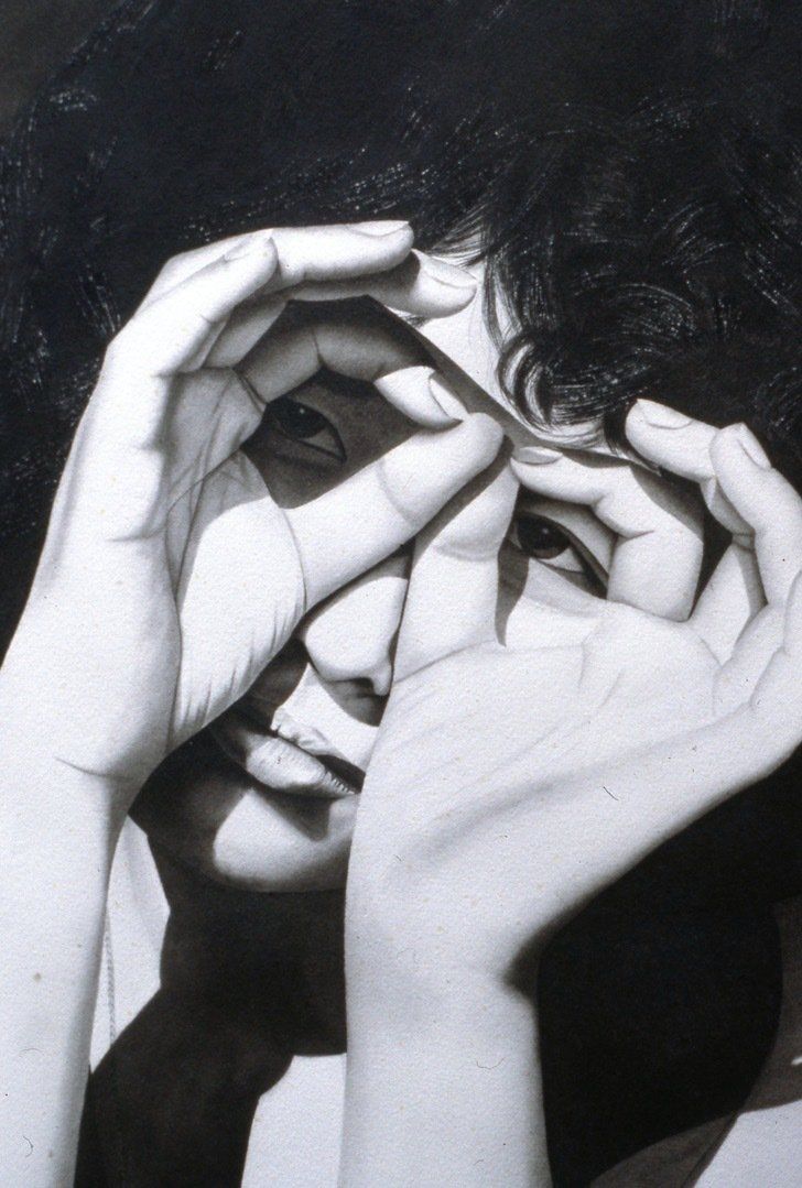 A black and white photo of a woman covering her face with her hands