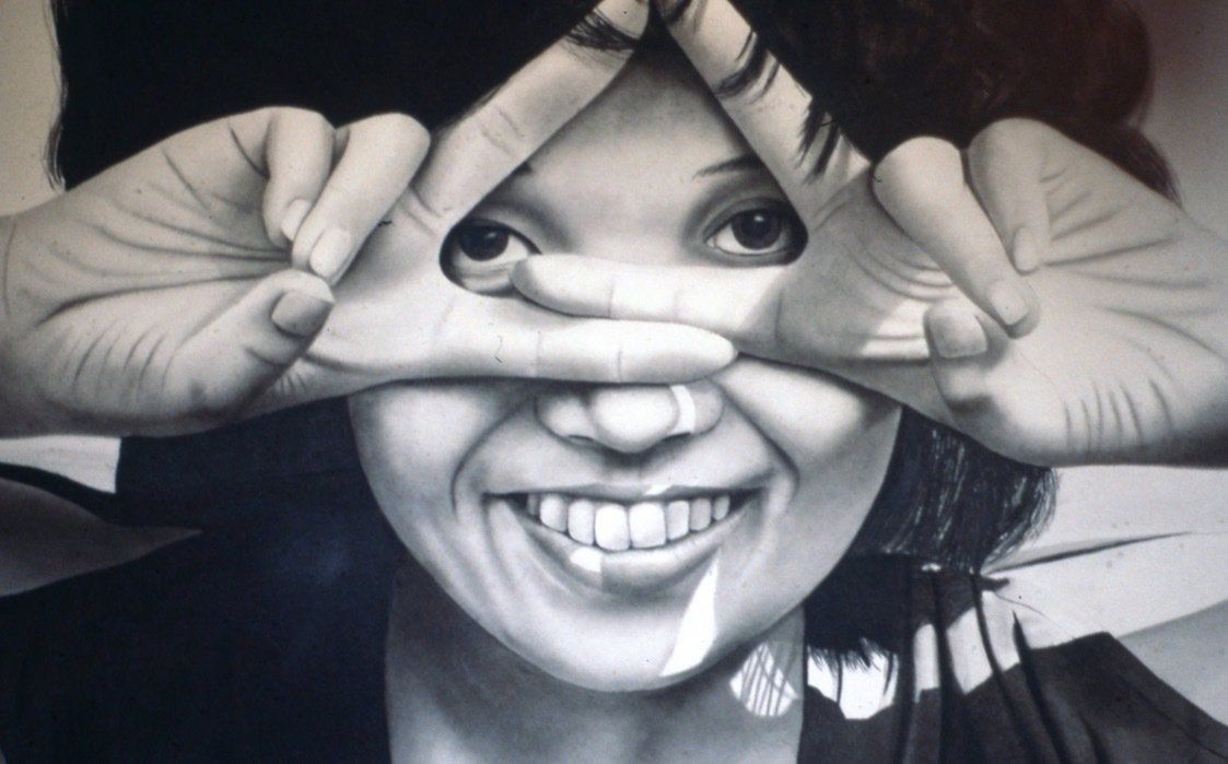 A woman covering her eyes with her hands and smiling