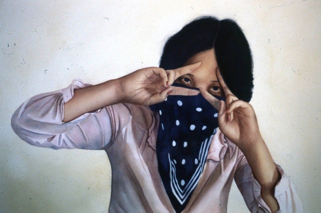 A woman covering her face with a blue bandana