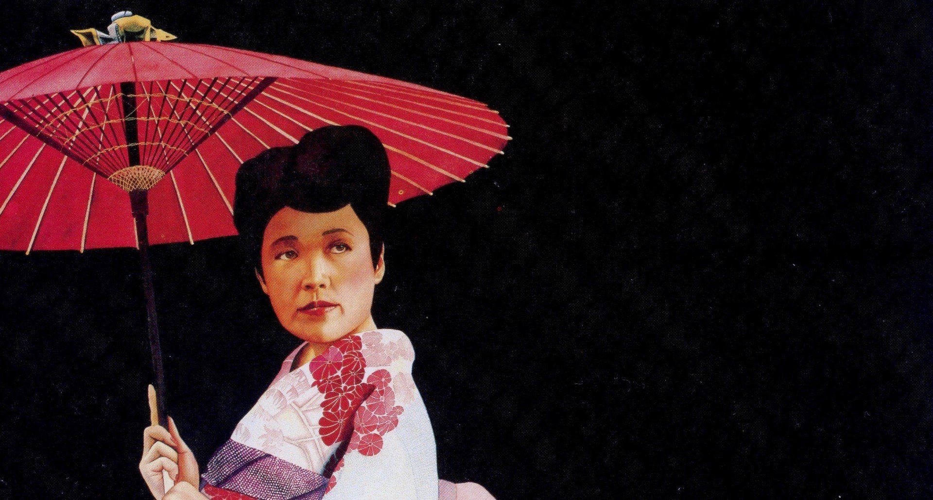 A woman in a kimono is holding a red umbrella.