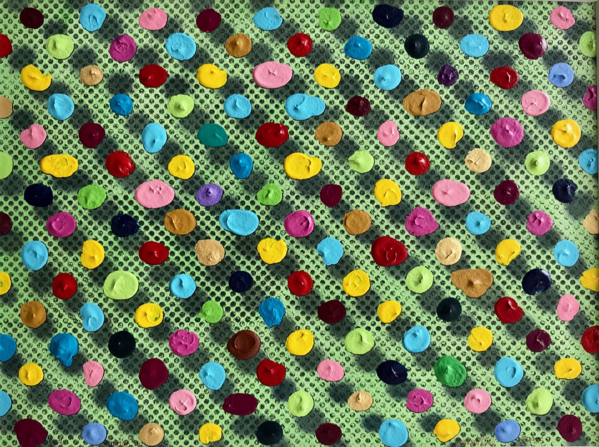 There are many different colored buttons on a green background.