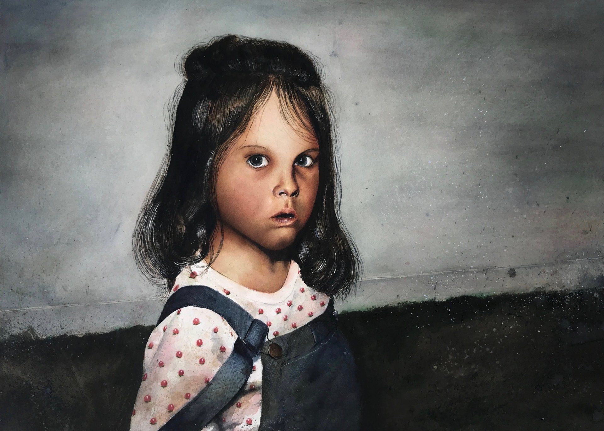 A little girl is wearing overalls and a polka dot shirt