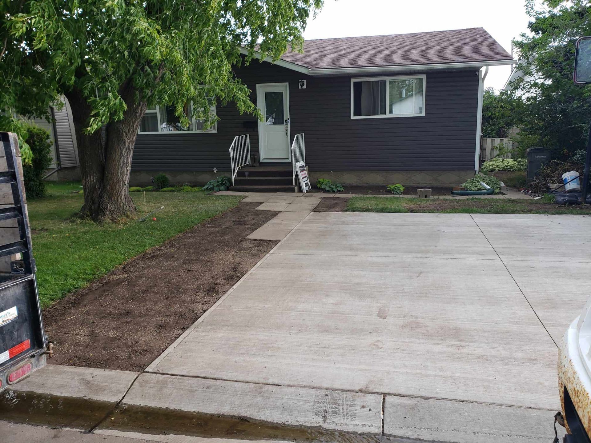 A house with a concrete driveway in front of it