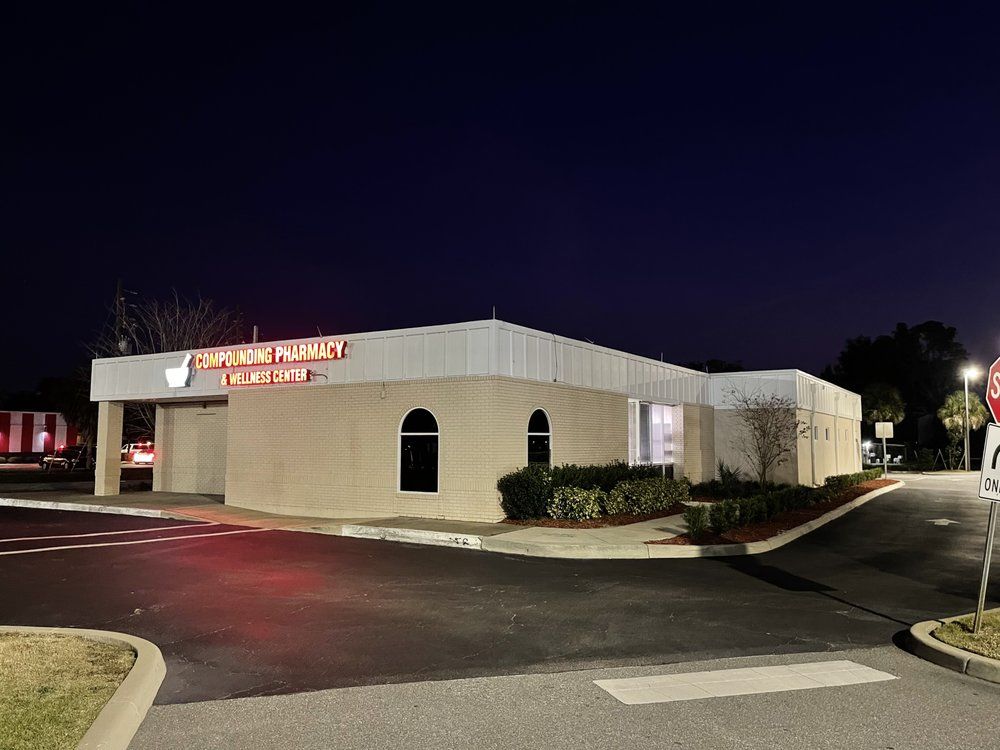Night shot of a light brick building with a sign that reads 