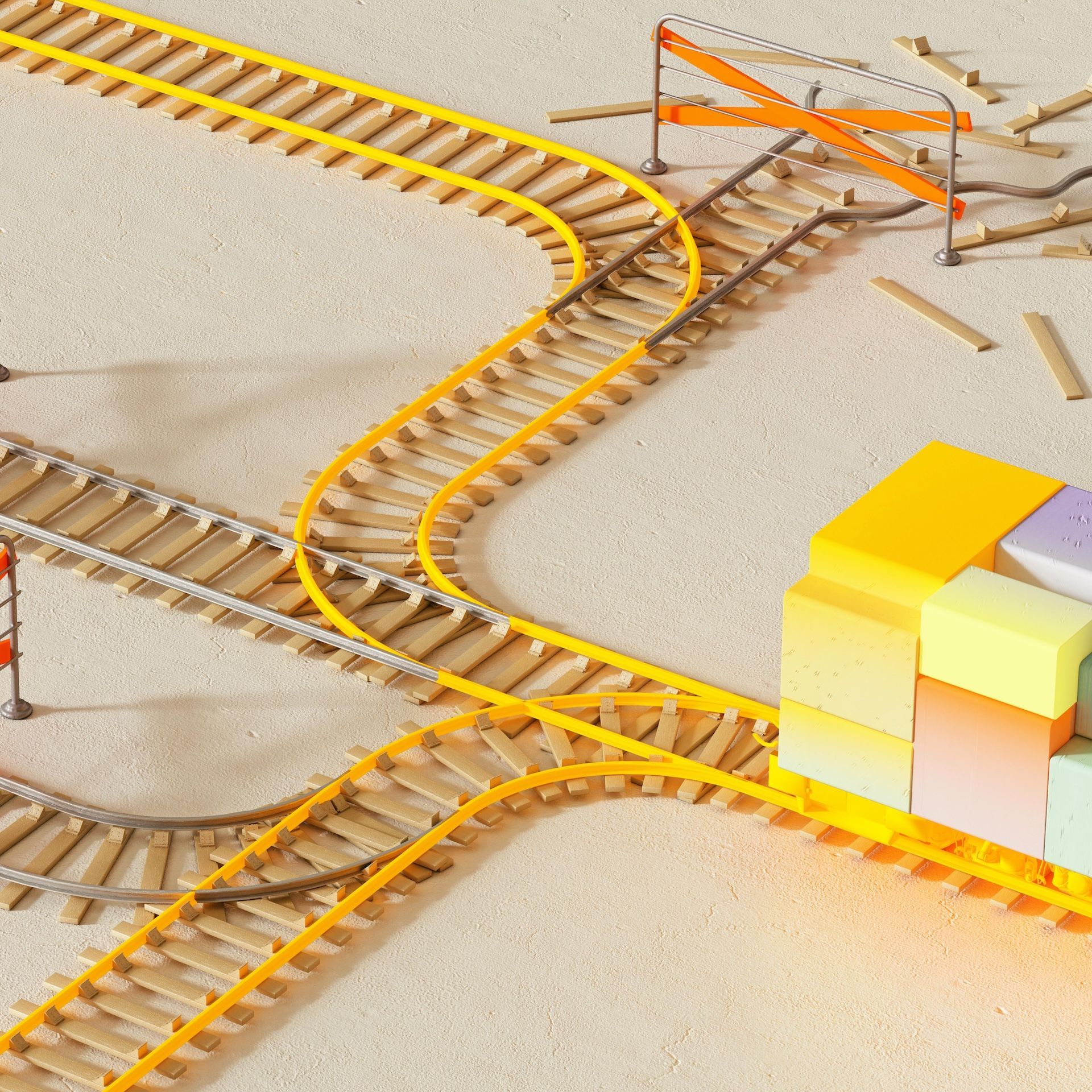 Speelgoedtreinrails met een kleurrijke blokkenstructuur in een zanderige omgeving.