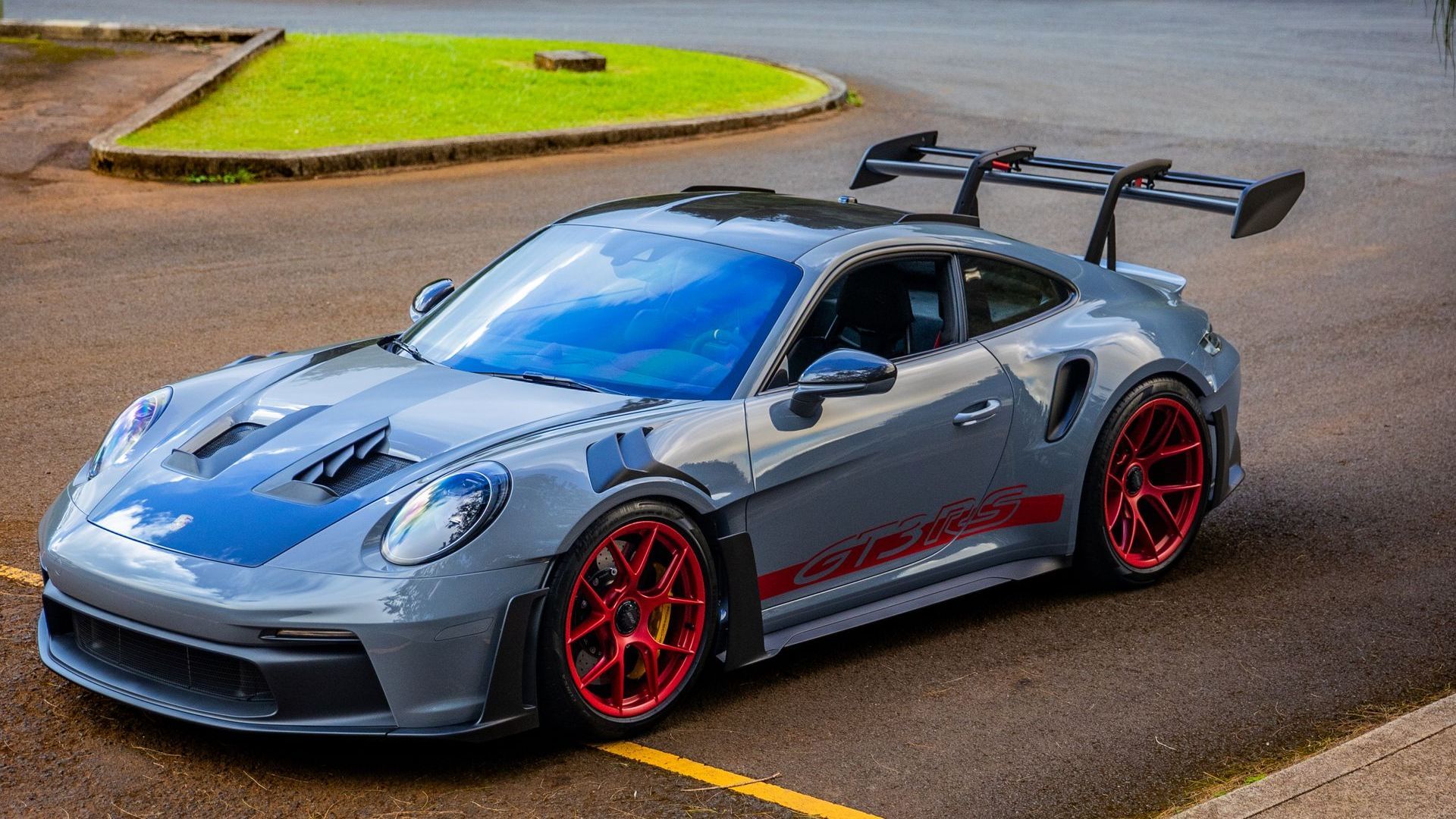 A gray porsche 911 gt3 rs is parked in a parking lot.