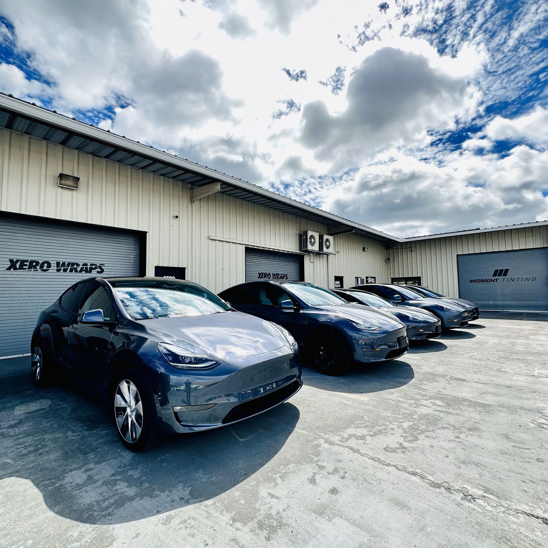 A row of cars are parked in front of a building that says keep your cars