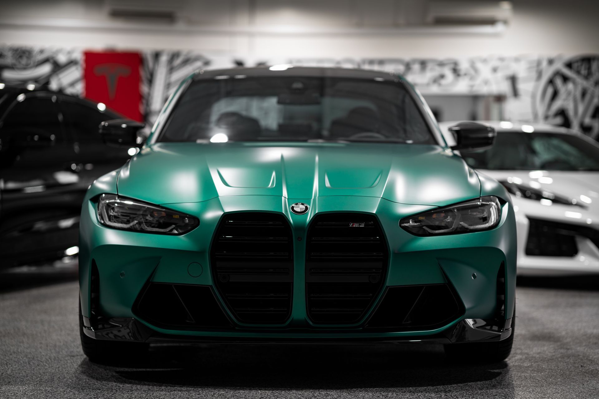 A green bmw m3 is parked in a garage.
