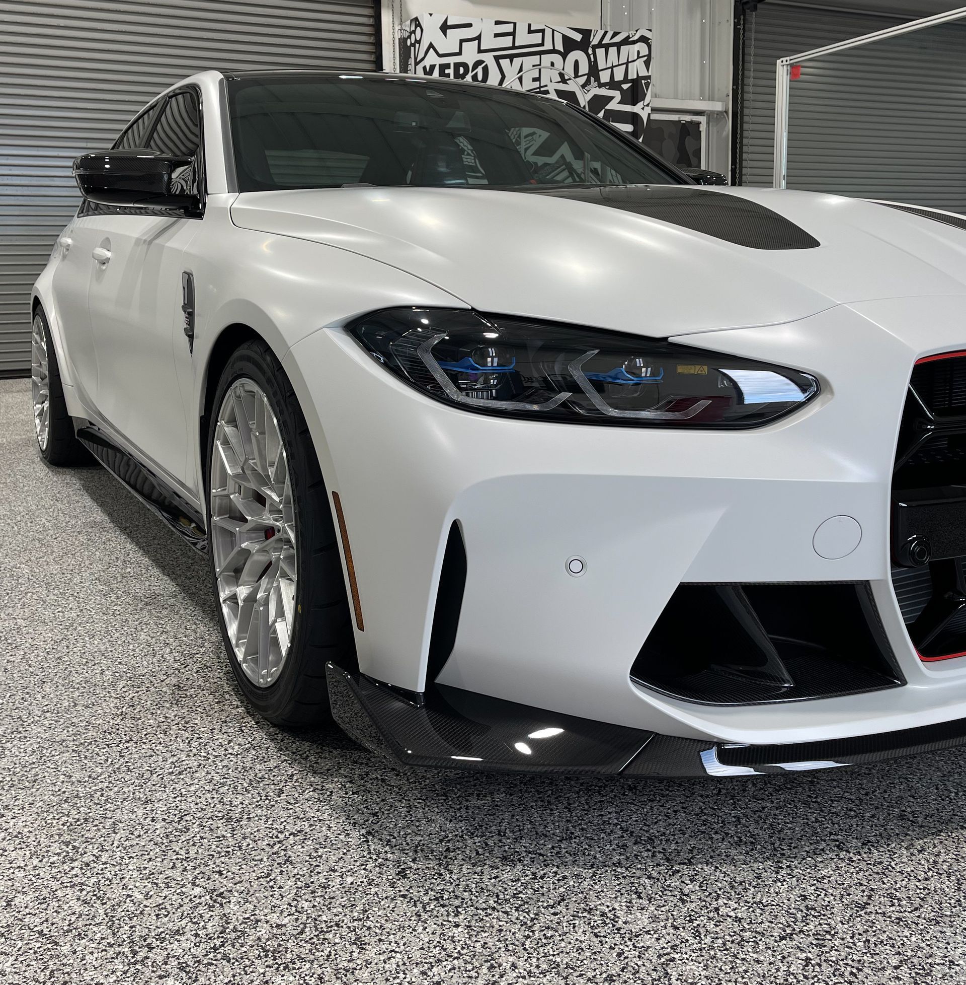 A white bmw m3 is parked in a garage.
