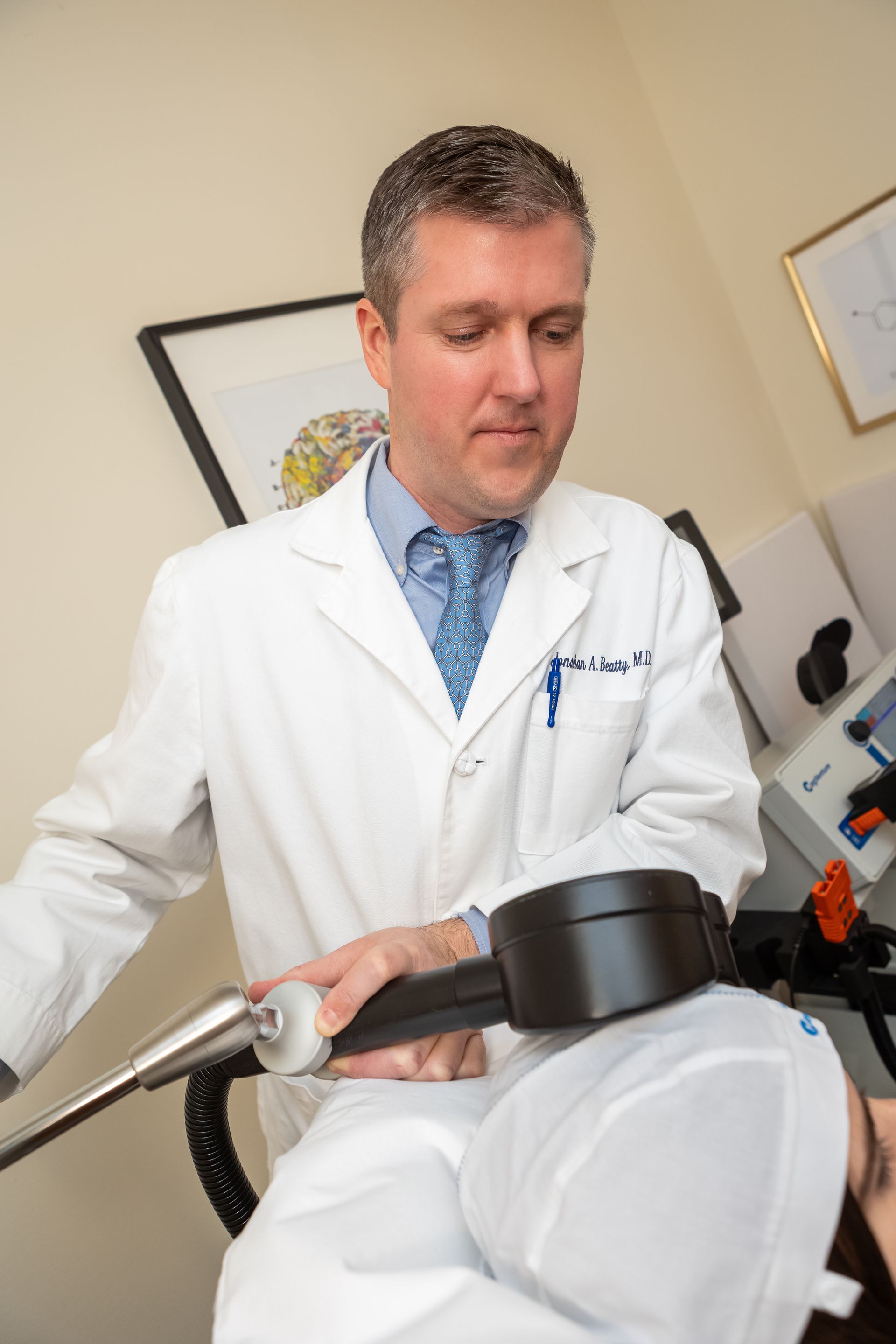 A doctor is using a machine on a patient 's head.