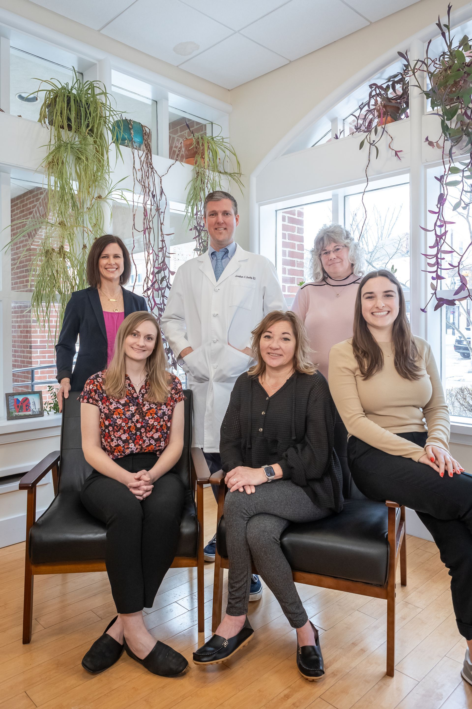 A group of people are sitting in chairs in a waiting room.