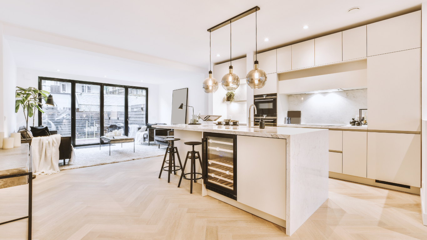 A kitchen with white cabinets and a large island in the middle of the room.