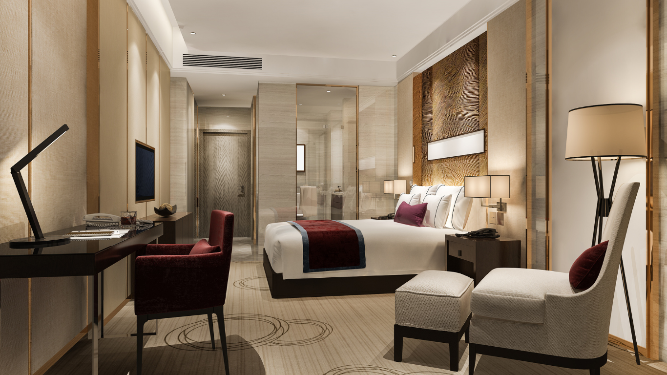 A hotel room with a bed , chairs , desk and television.