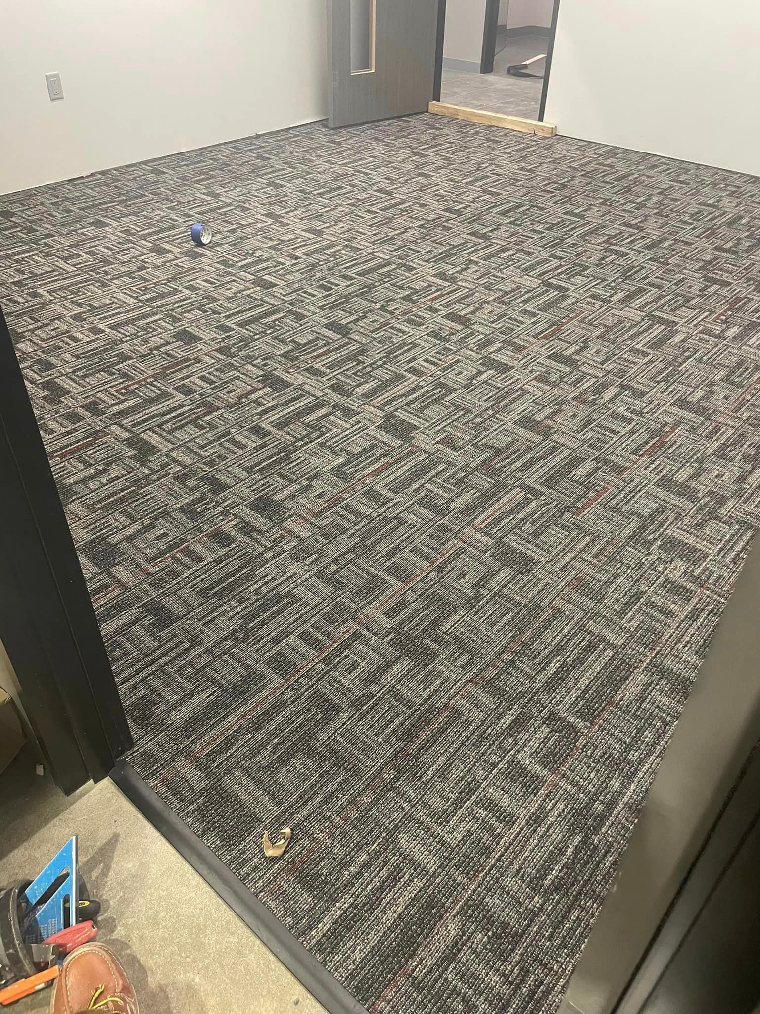 A carpeted floor in a room with a door in the background.