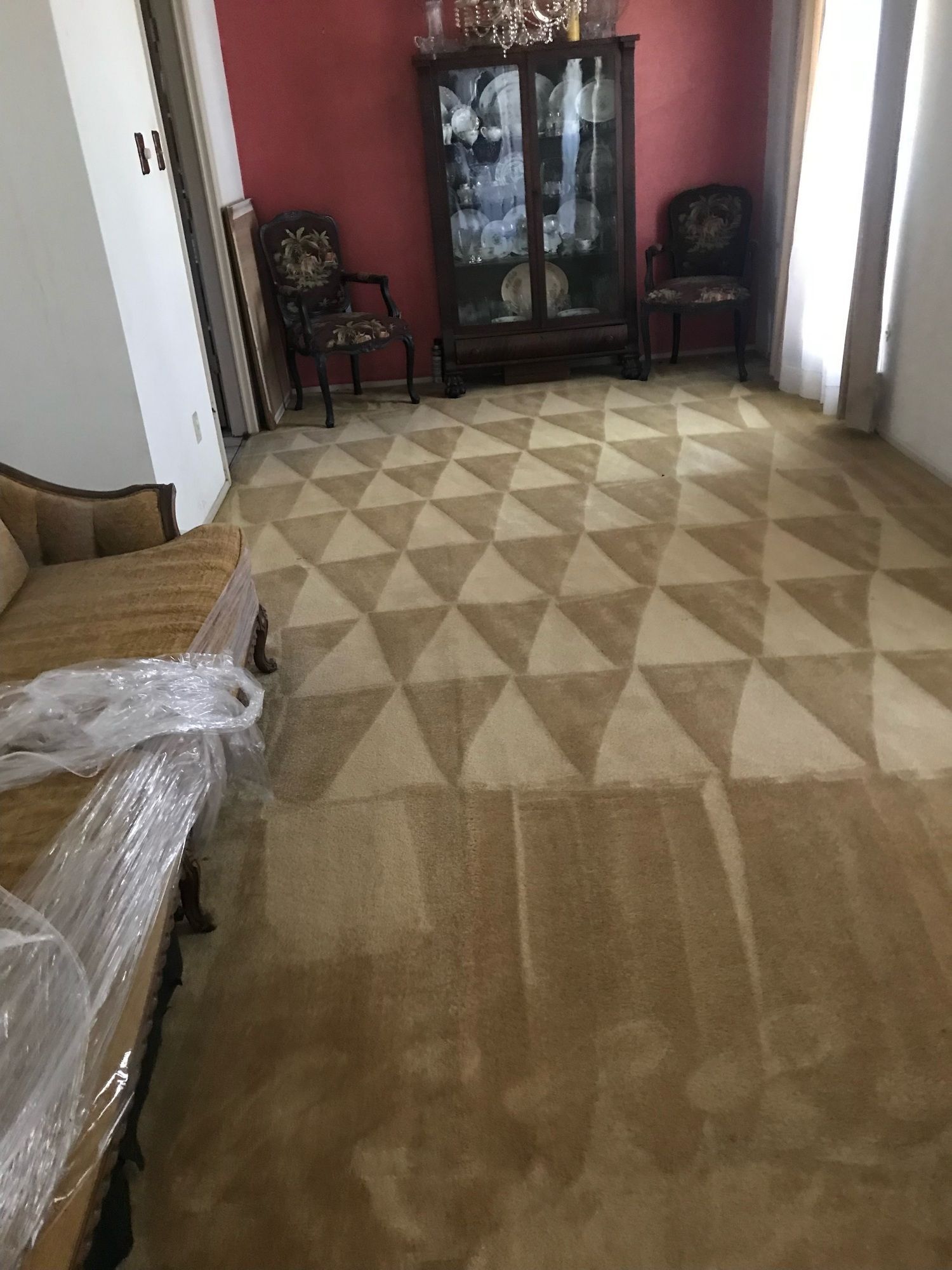 A living room with a couch and chairs and a rug on the floor.