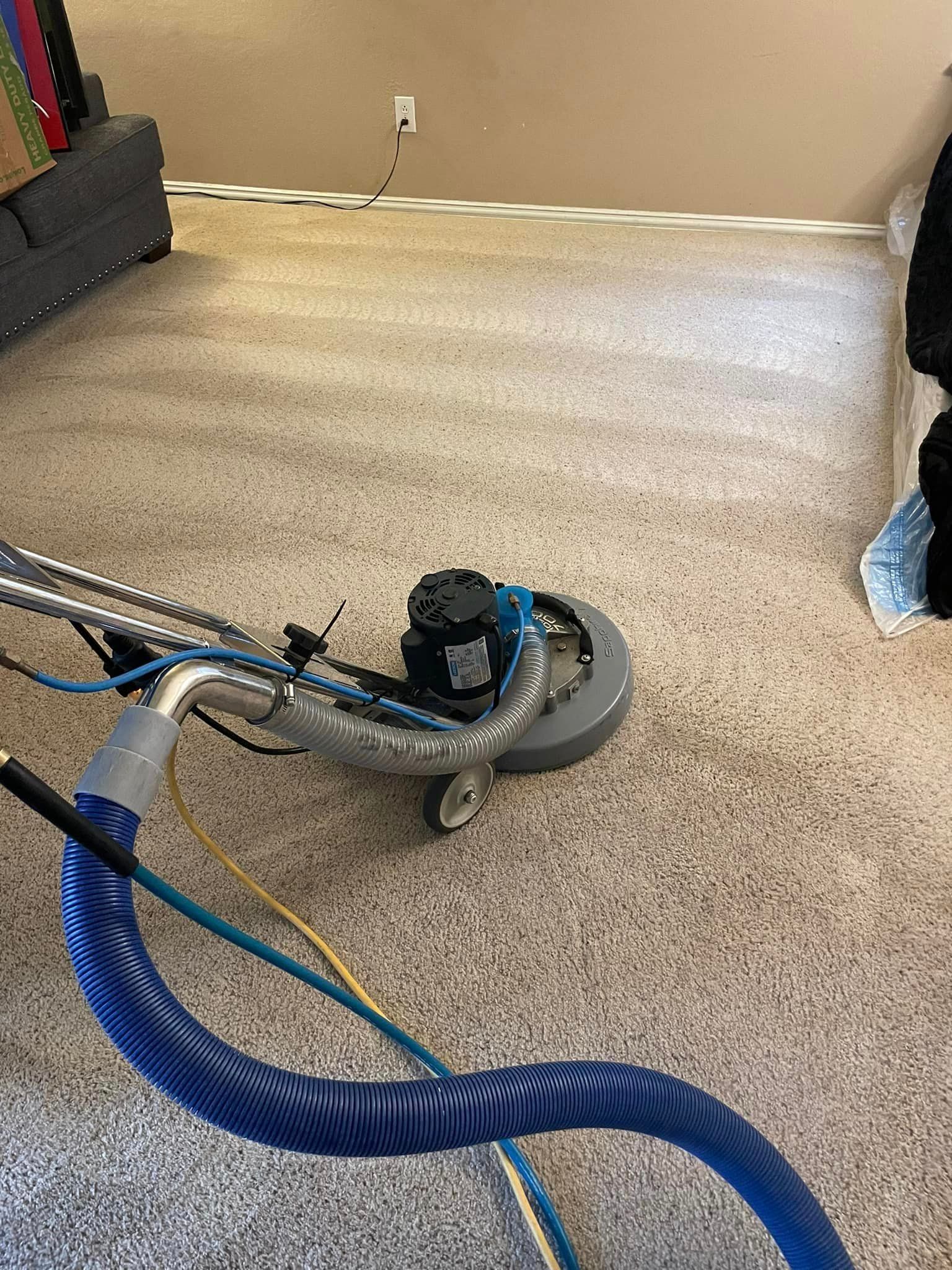 A vacuum cleaner is sitting on top of a carpet in a living room.