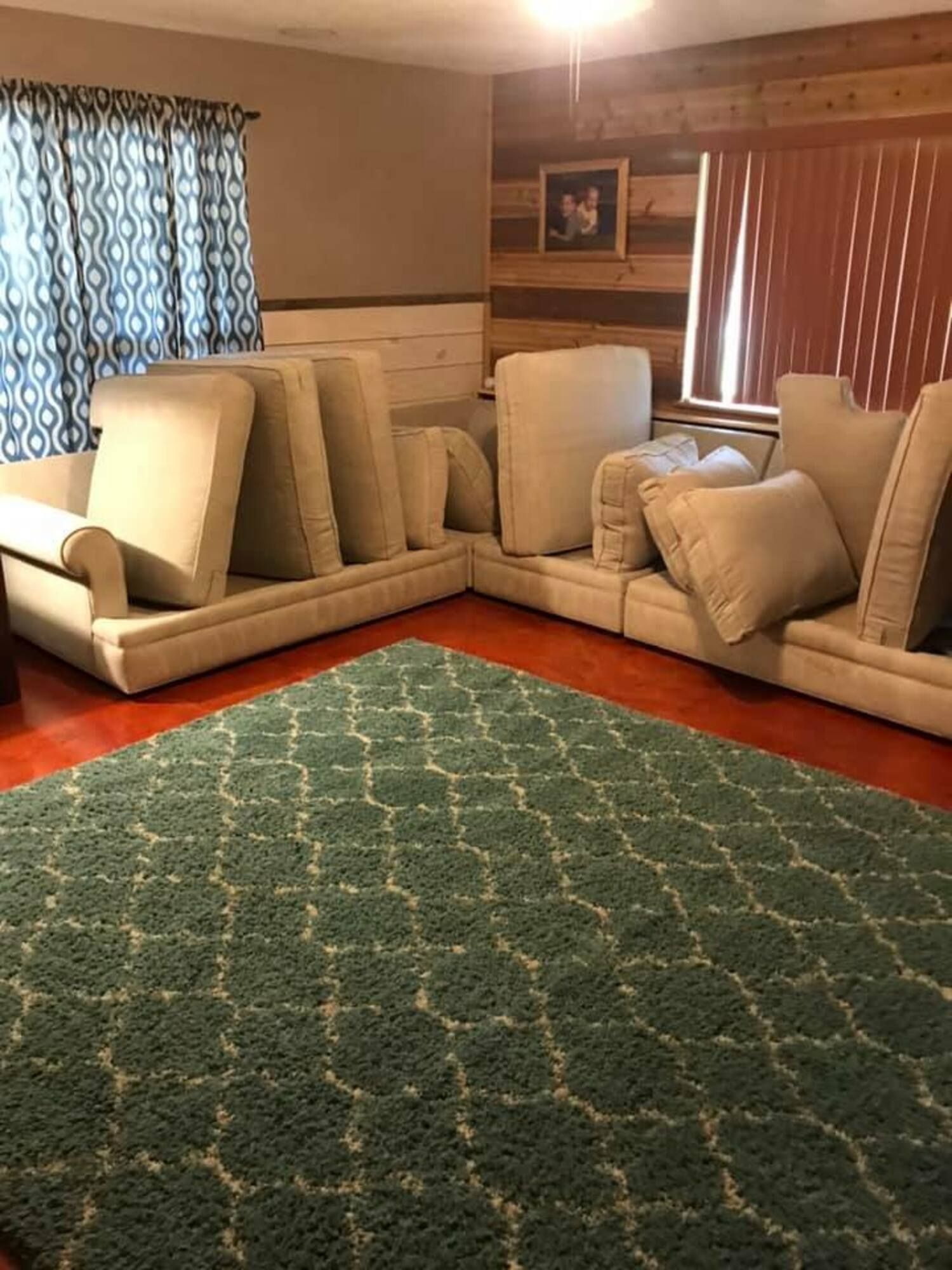 A living room filled with furniture and a green rug.