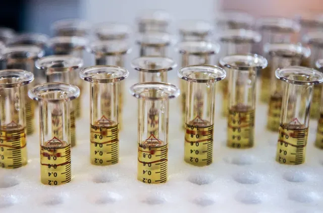 A bunch of test tubes filled with liquid are sitting on a table.