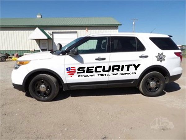 A white security vehicle is parked in front of a building