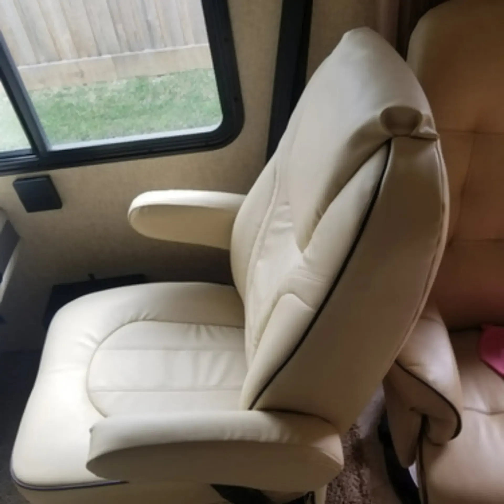 Piece By Piece of Houston LLC
 - A white leather chair is sitting in front of a window