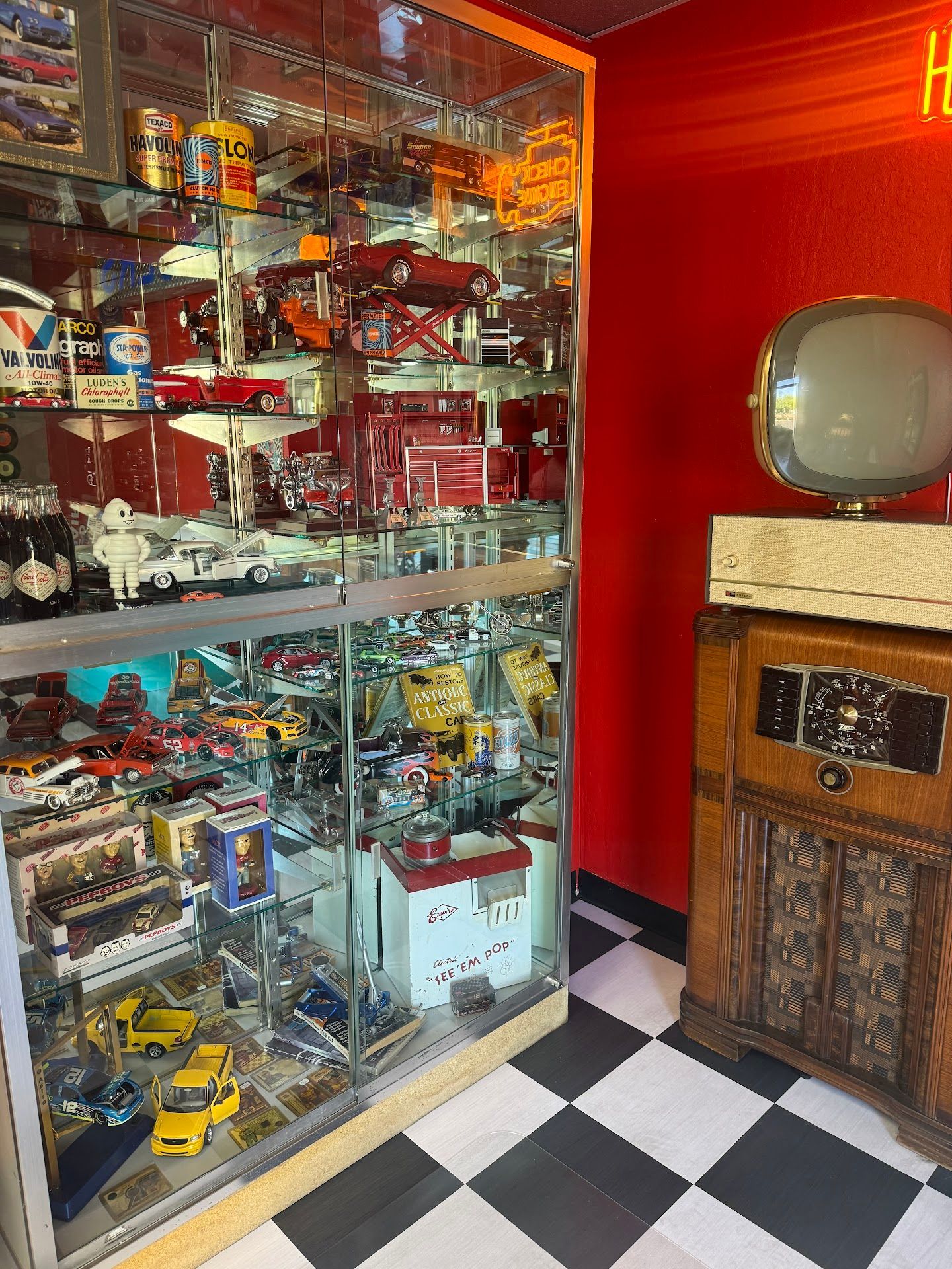 Display Cabinet with Toy Cars, Next to a Vintage Television | Greasers Automotive