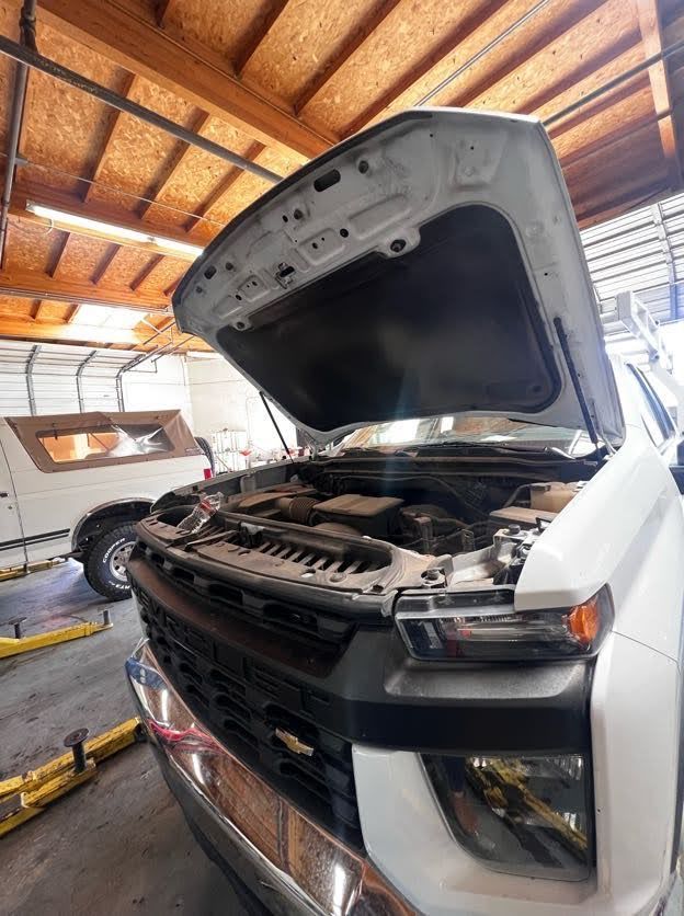 White Pickup Truck with Hood up in a Repair Shop | Greasers Automotive