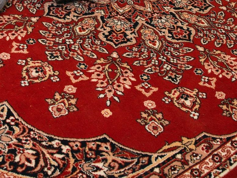 A red rug with a floral pattern on it