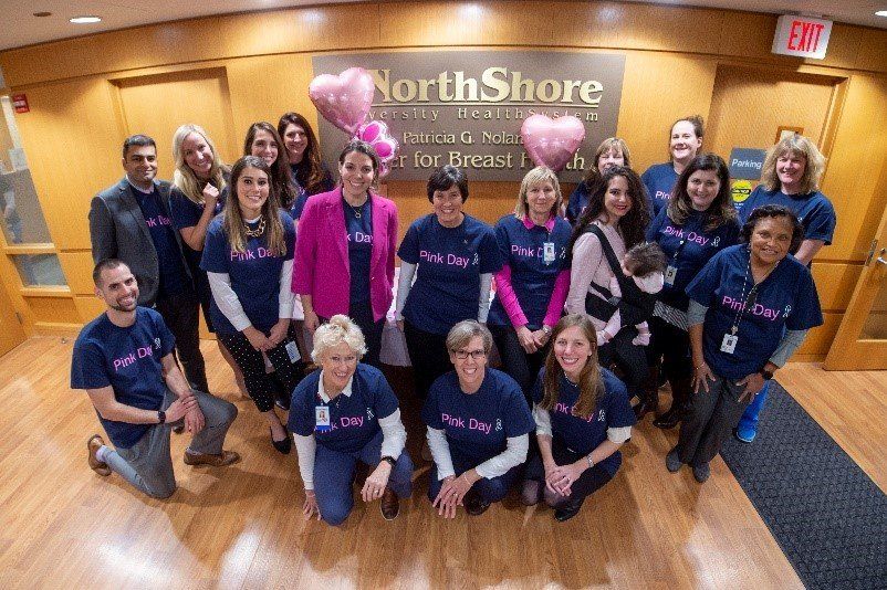 A group of people posing in front of a sign that says north shore