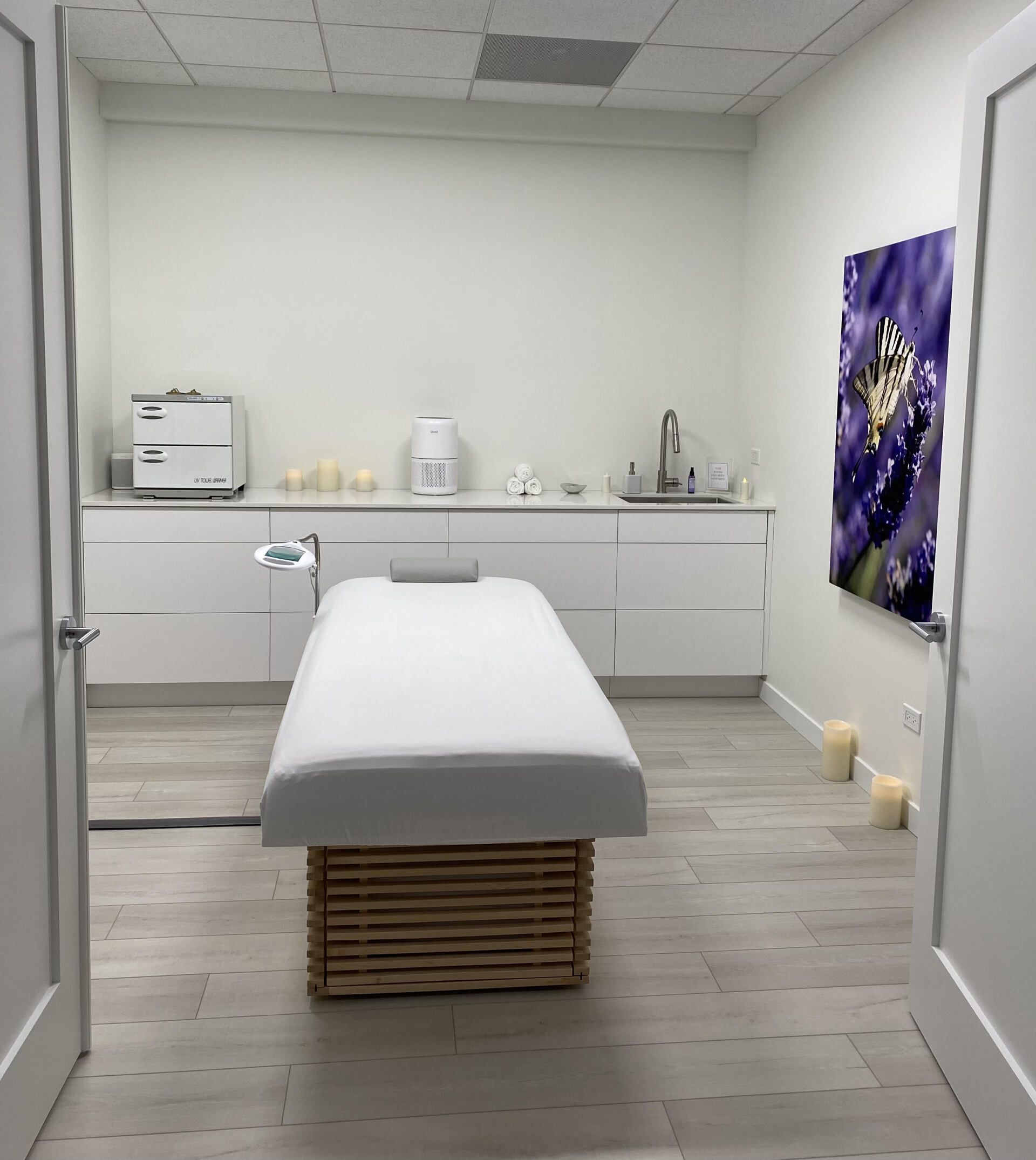 A massage table in a room with a picture of flowers on the wall