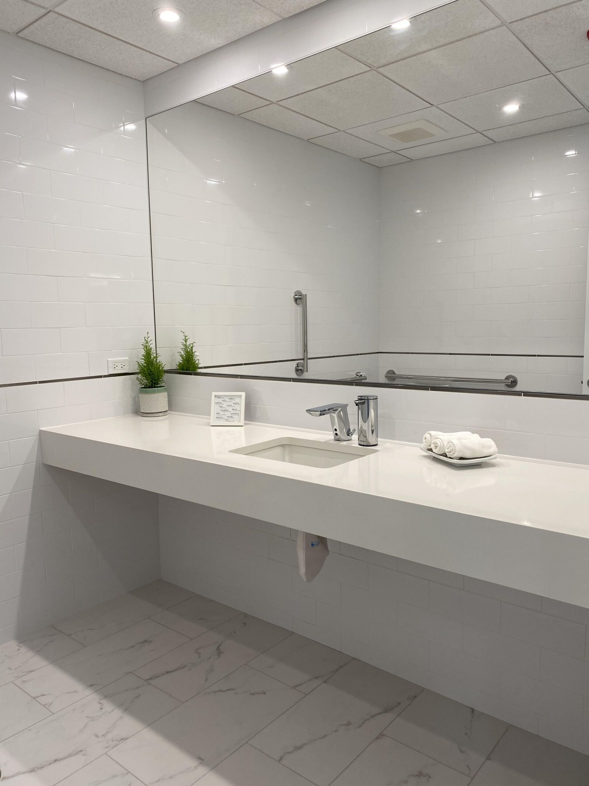 A bathroom with a sink and a large mirror