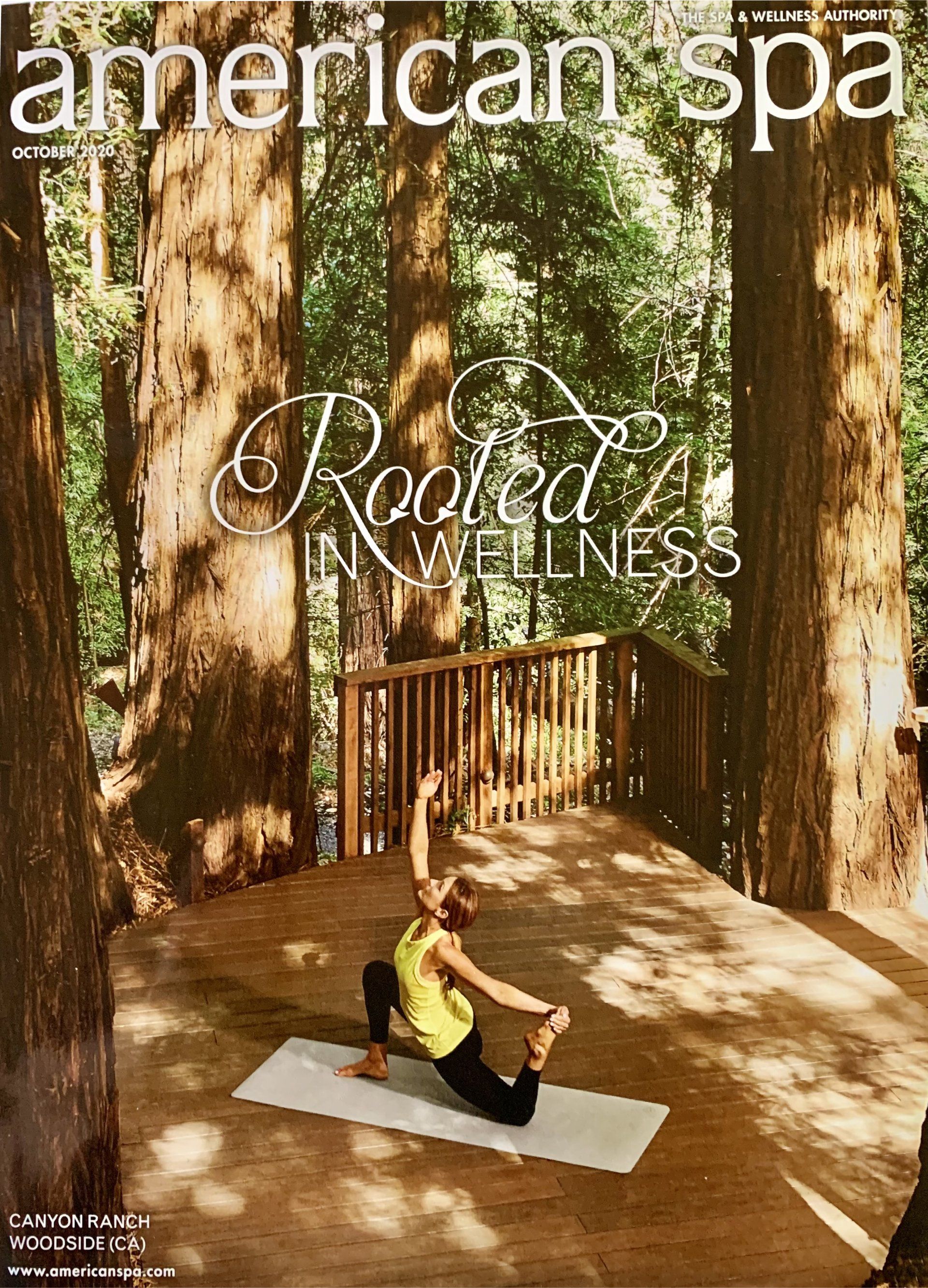 A woman is doing yoga on a deck in the woods.