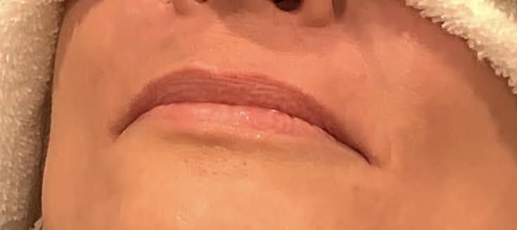 A close up of a woman 's lips with a towel wrapped around her head.
